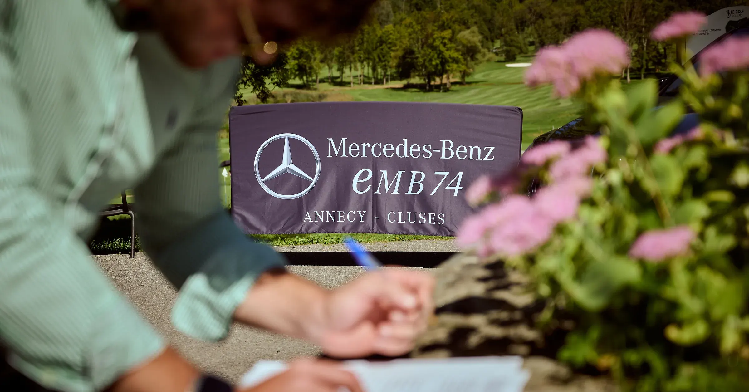 Bannière Mercedes-Benz EMB 74 au golf de Giez, invité au premier plan flou, reportage événementiel automobile