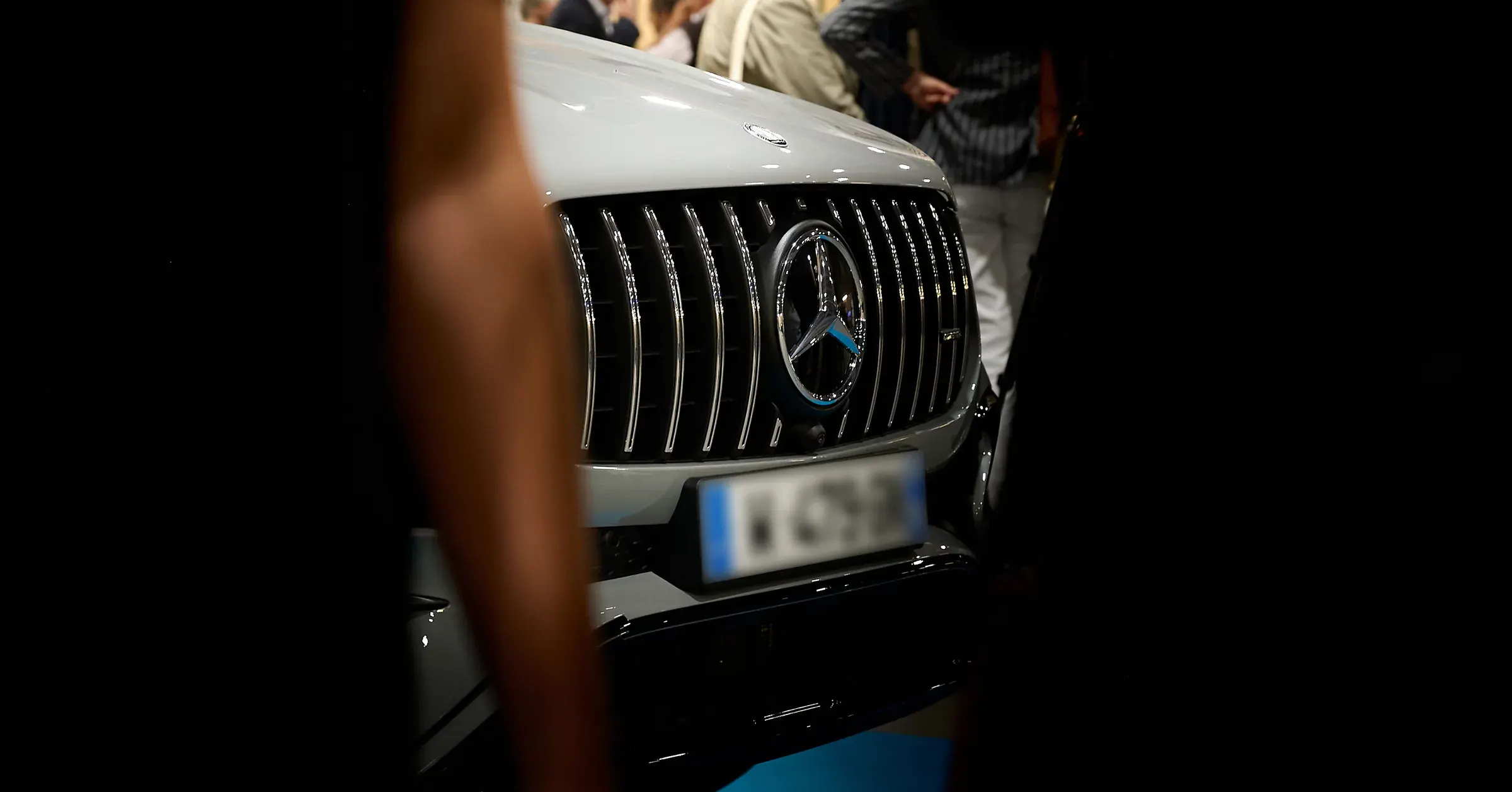 Calandre Panamericana AMG et étoile chromée d'une Mercedes-Benz grise vue entre les invités, photographe automobile à La Roche-sur-Foron
