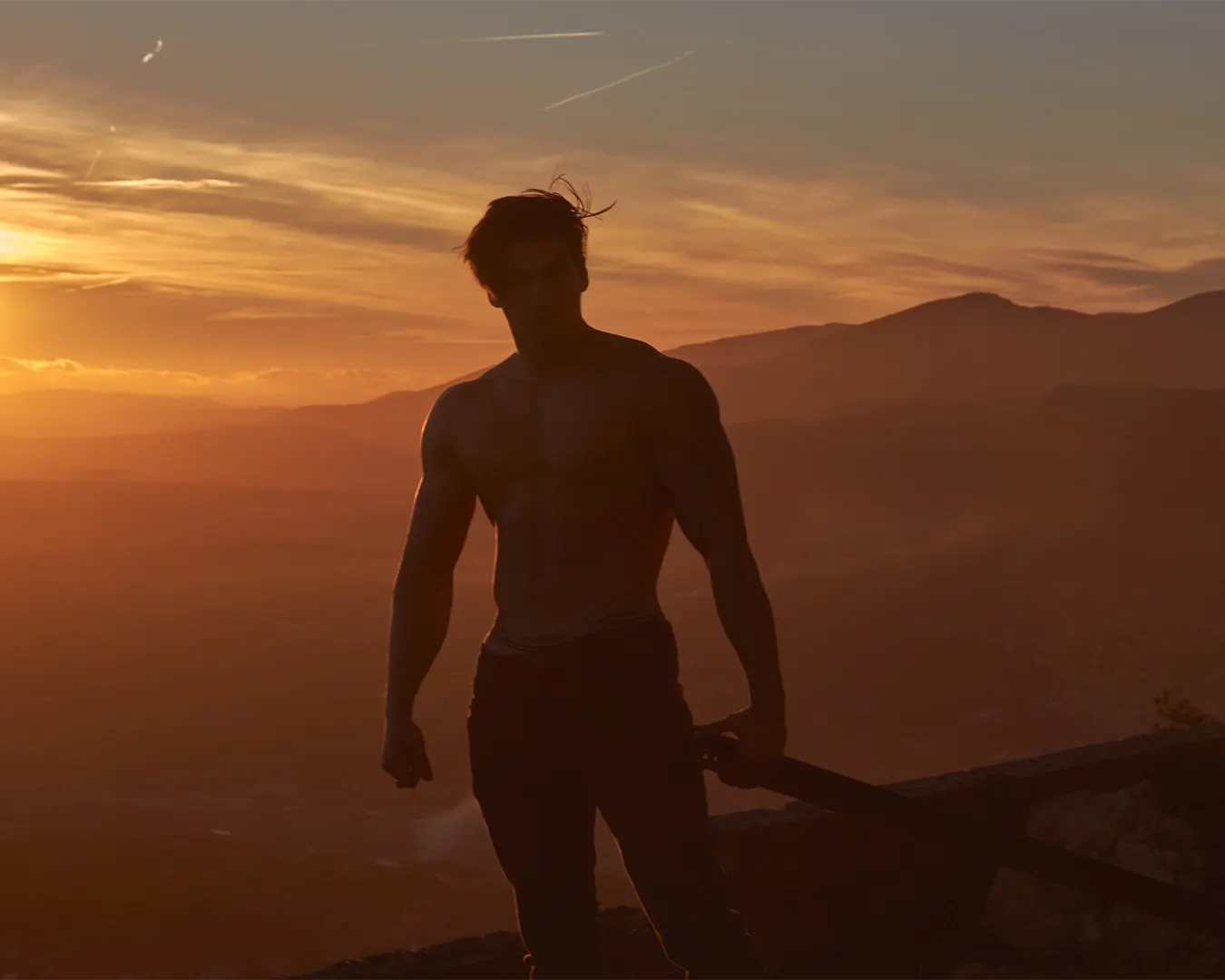 Athlète torse nu en contre-jour sur un sommet au coucher du soleil, séance fitness en montagne sur la Côte d'Azur
