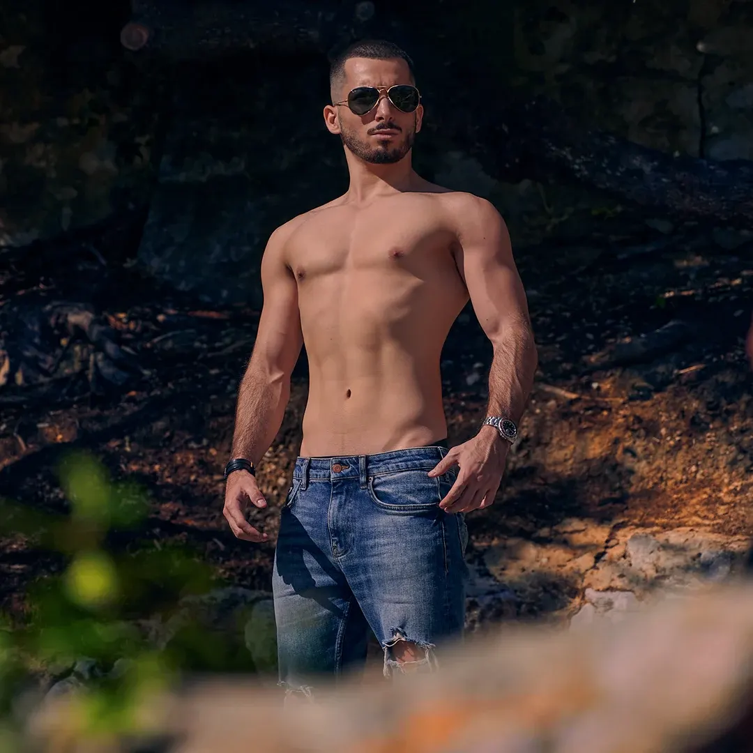 Athlète torse nu et musclé en jeans posant en extérieur, séance photo fitness et mode sur la Côte d'Azur