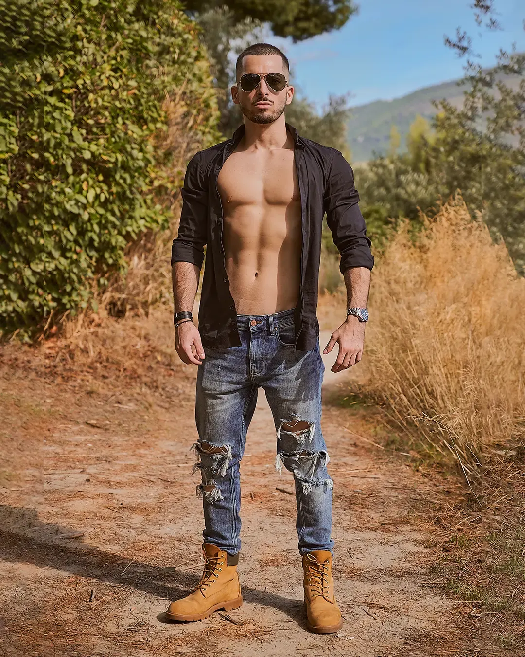 Portrait fitness masculin en extérieur, chemise ouverte et torse sculpté, sur un sentier de garrigue méditerranéenne, Côte d'Azur
