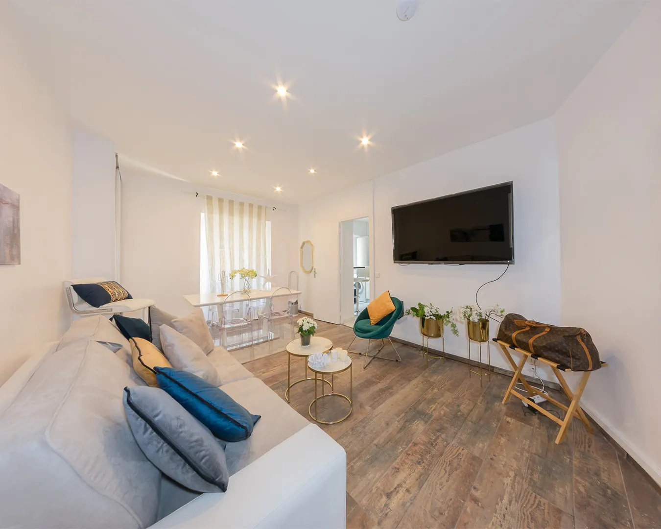 Salon lumineux d'un appartement contemporain, canapé et écran mural, photographie immobilière en Suisse romande et France