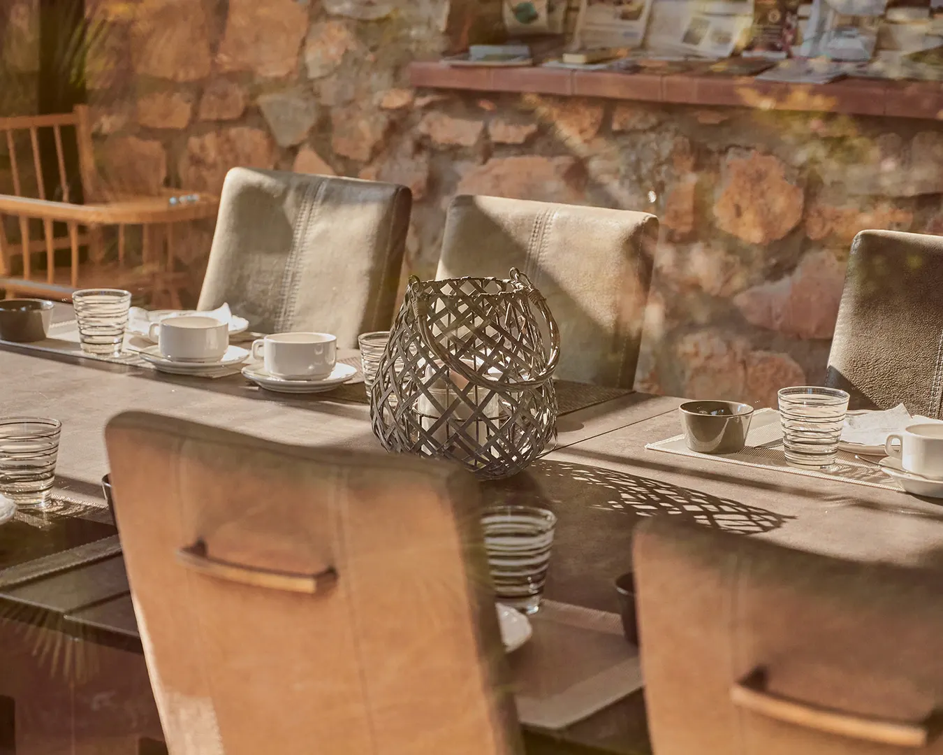 Table d'hôtes dressée en pierre et bois, photographie d'intérieur immobilier haut de gamme en Suisse romande