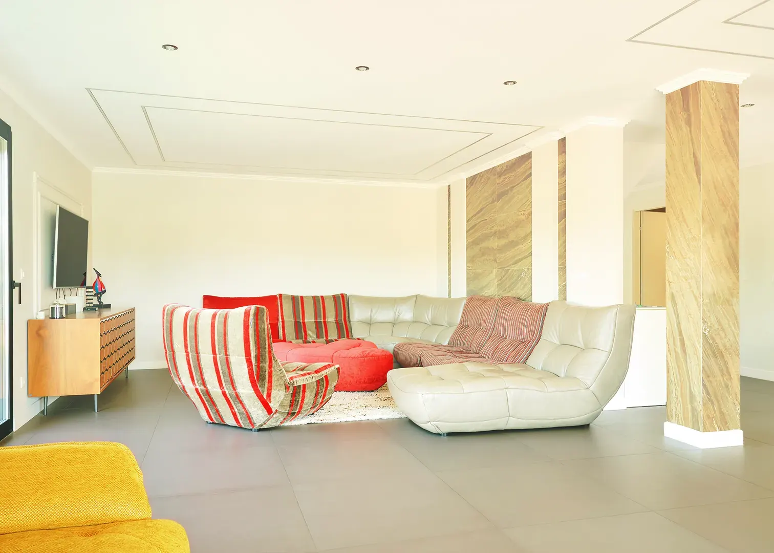 Salon contemporain d'une villa de luxe, canapés design et colonnes en marbre, photographie immobilière en Suisse romande