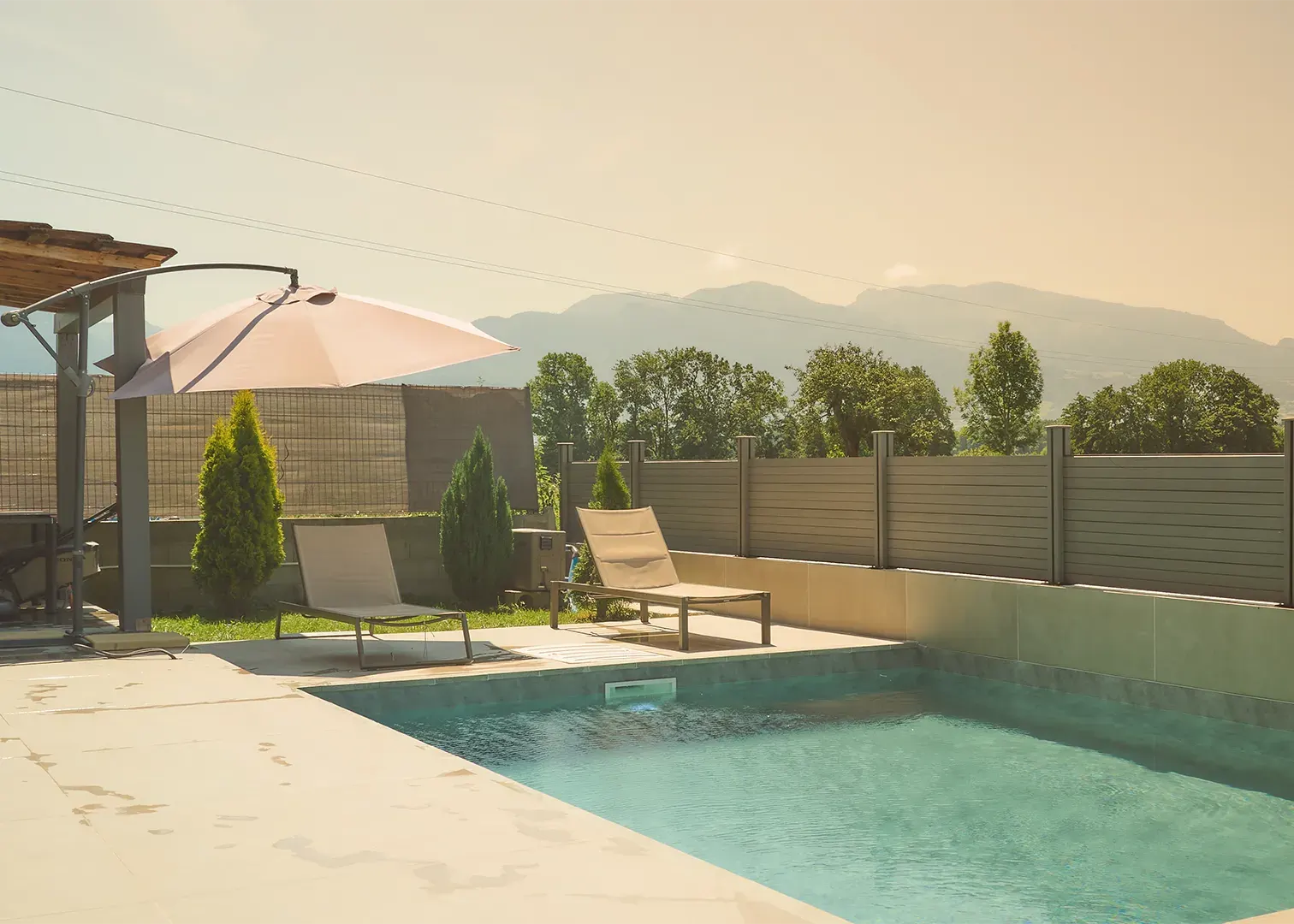 Terrasse avec piscine, transats et vue sur les montagnes, photographie immobilière haut de gamme