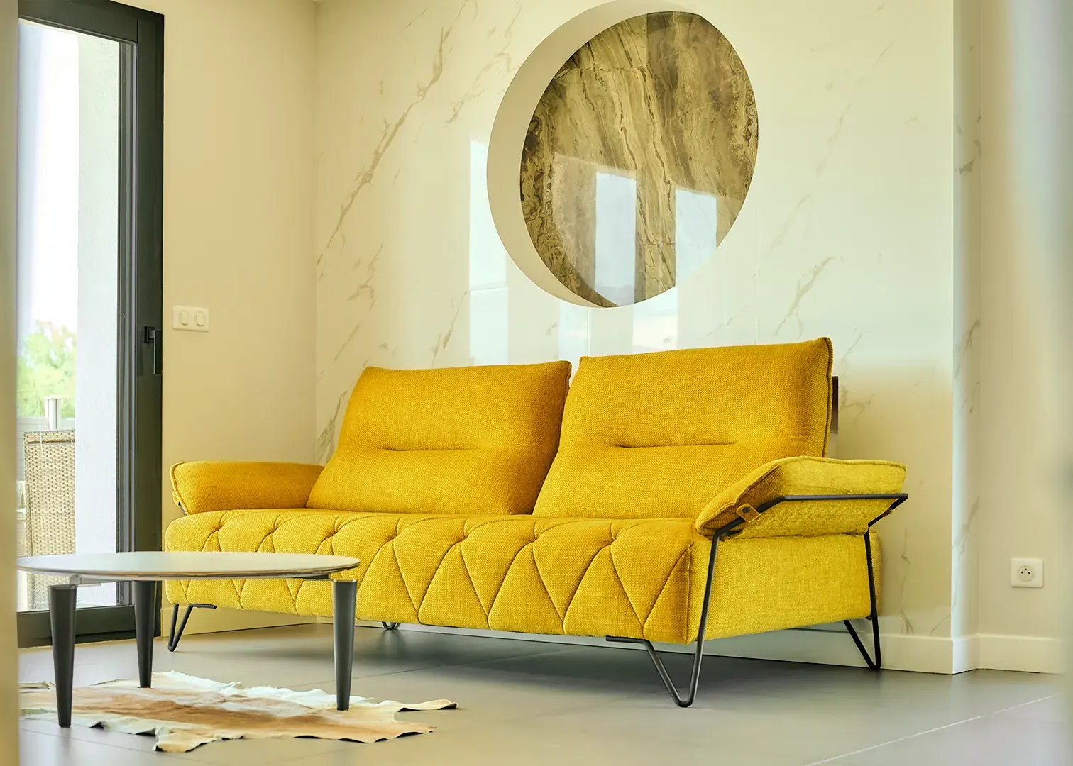 Salon contemporain avec canapé jaune moutarde et mur en marbre, photographie d'intérieur immobilier haut de gamme